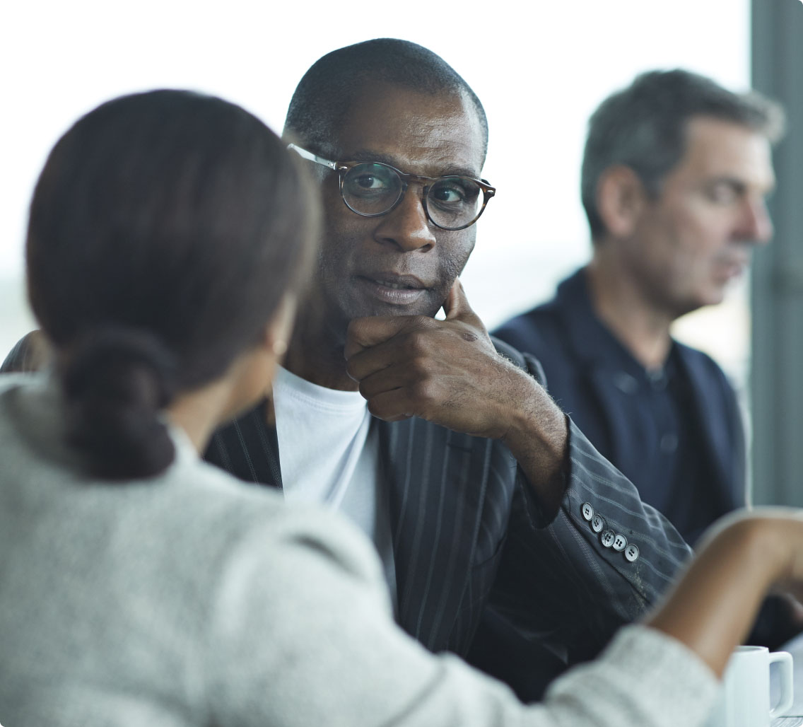 shallow depth of field image african american man with modern glasses and suit jacket listens to woman speak